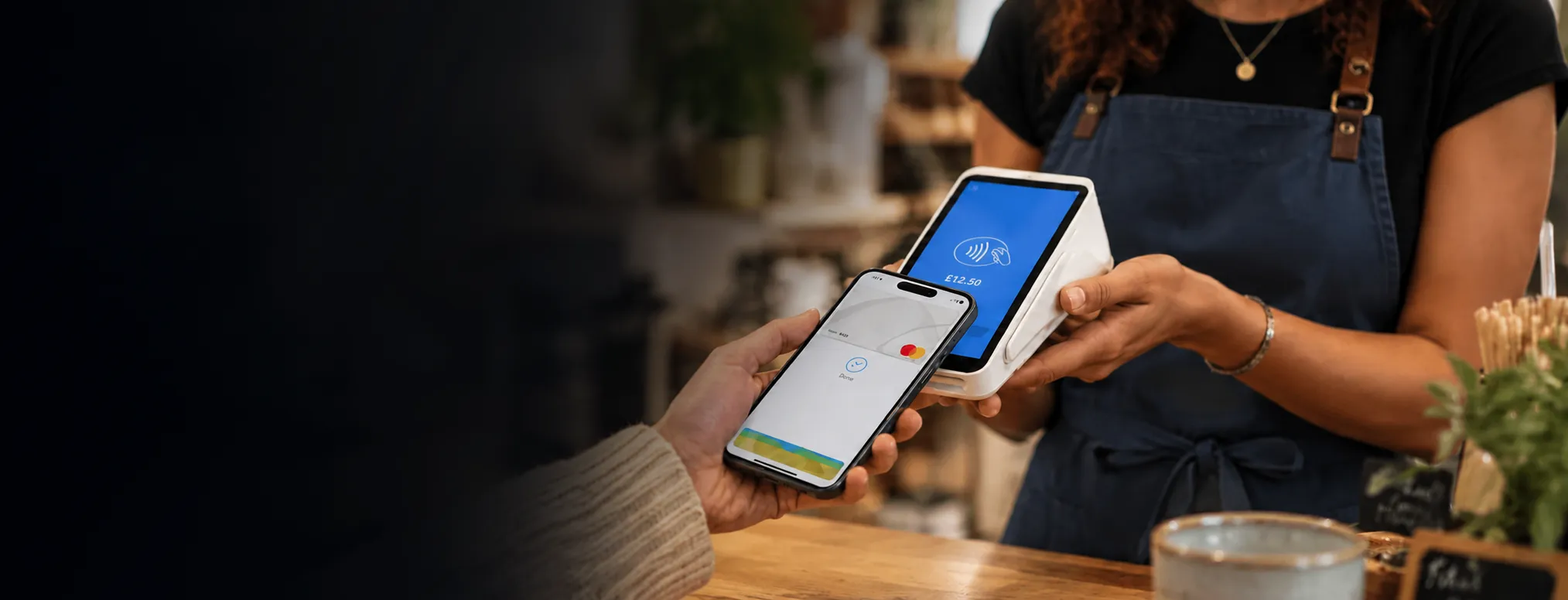 Tapping a phone against a handheld card machine to pay