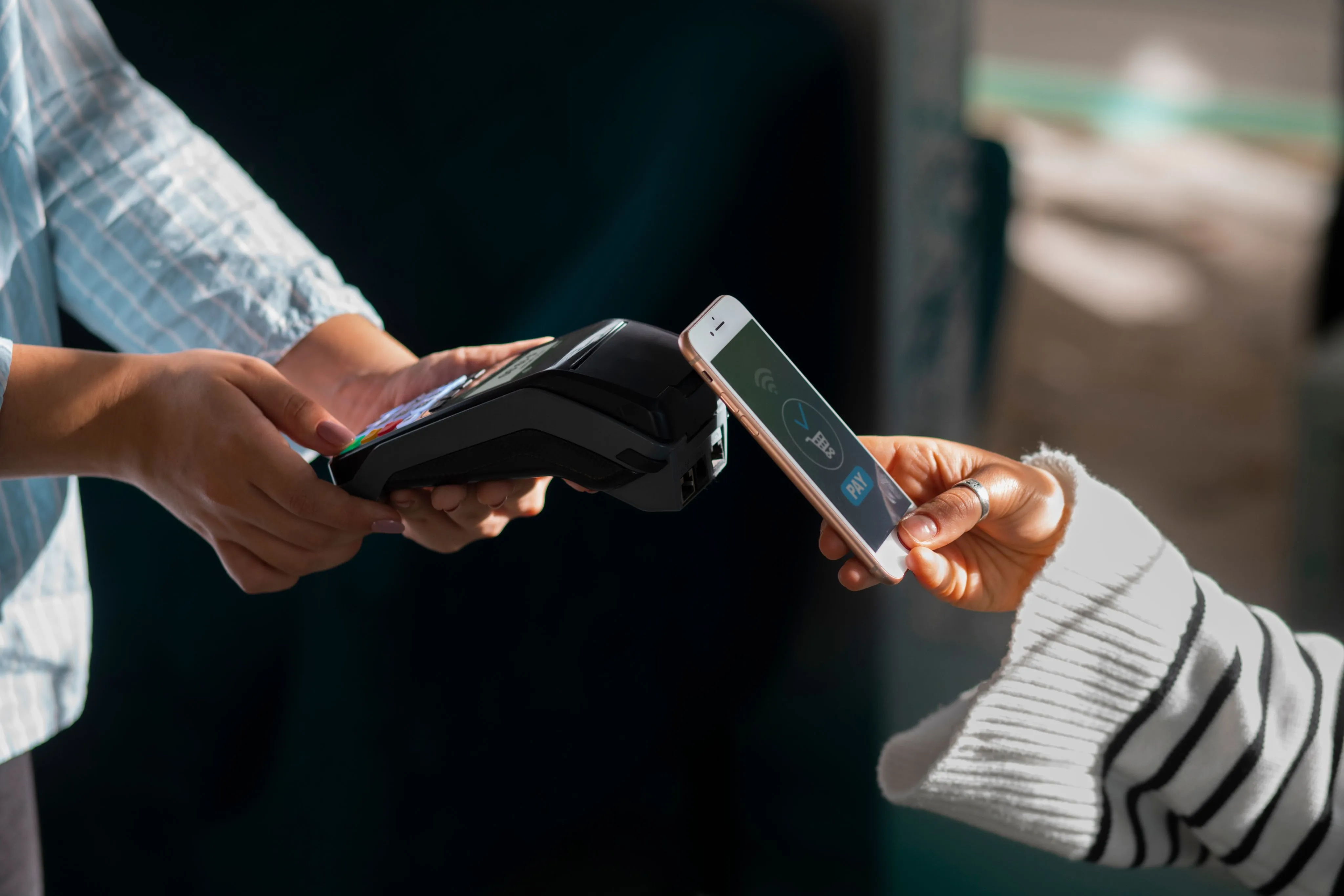 A customer paying by phone on a card terminal