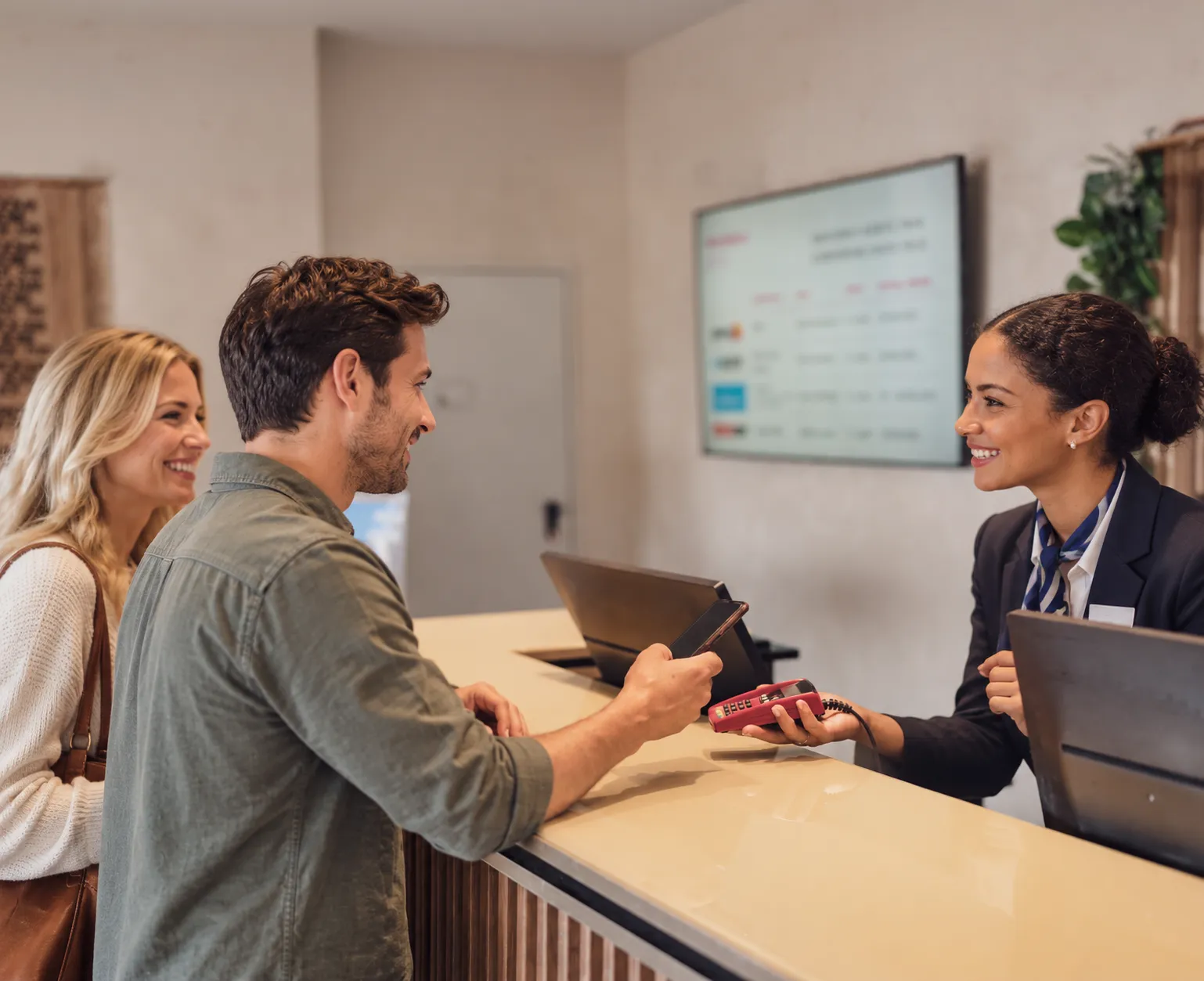 A hotel receptionist taking a contactless payment from a guest