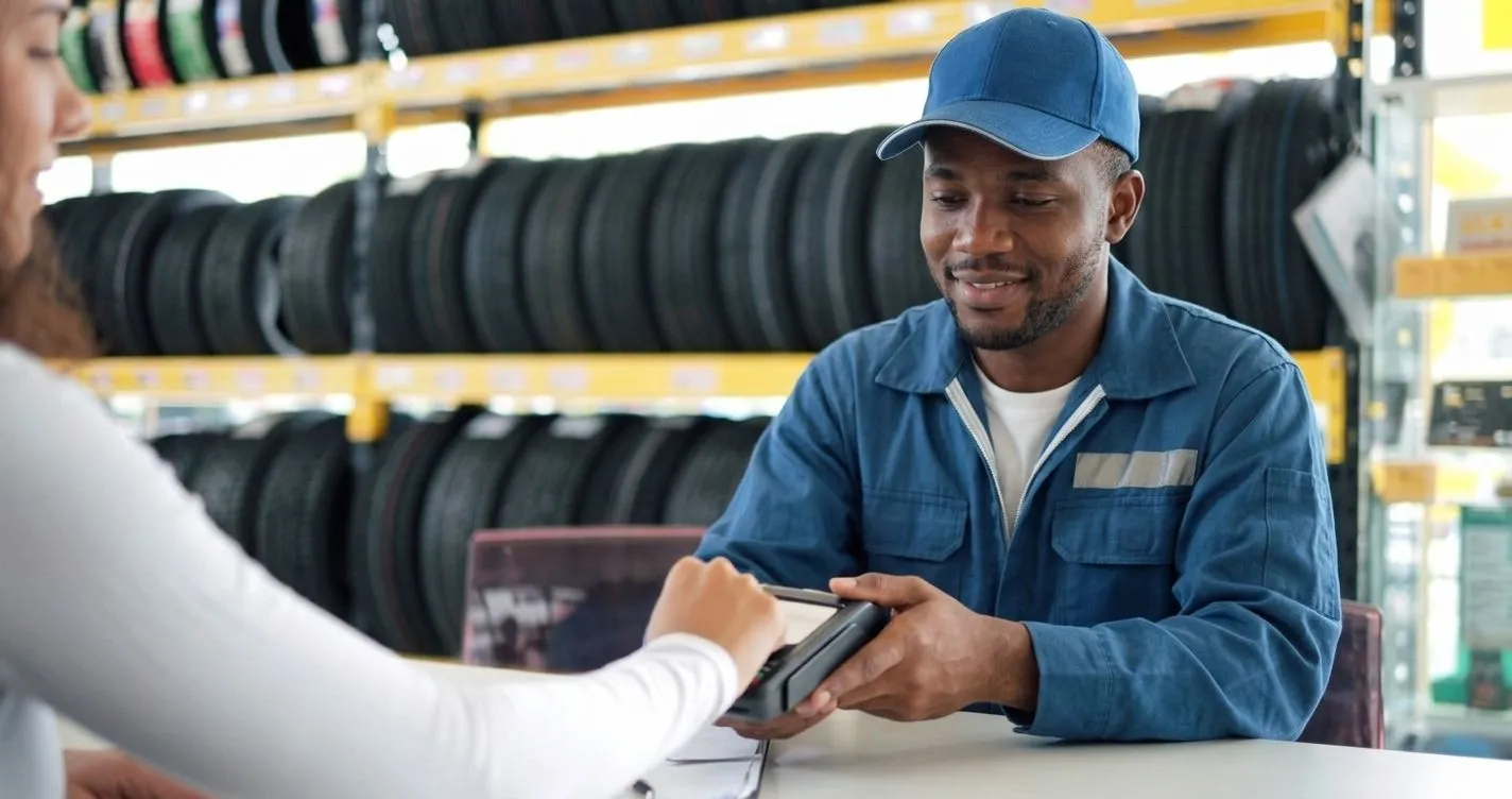 A mechanic taking a card payment at the counter