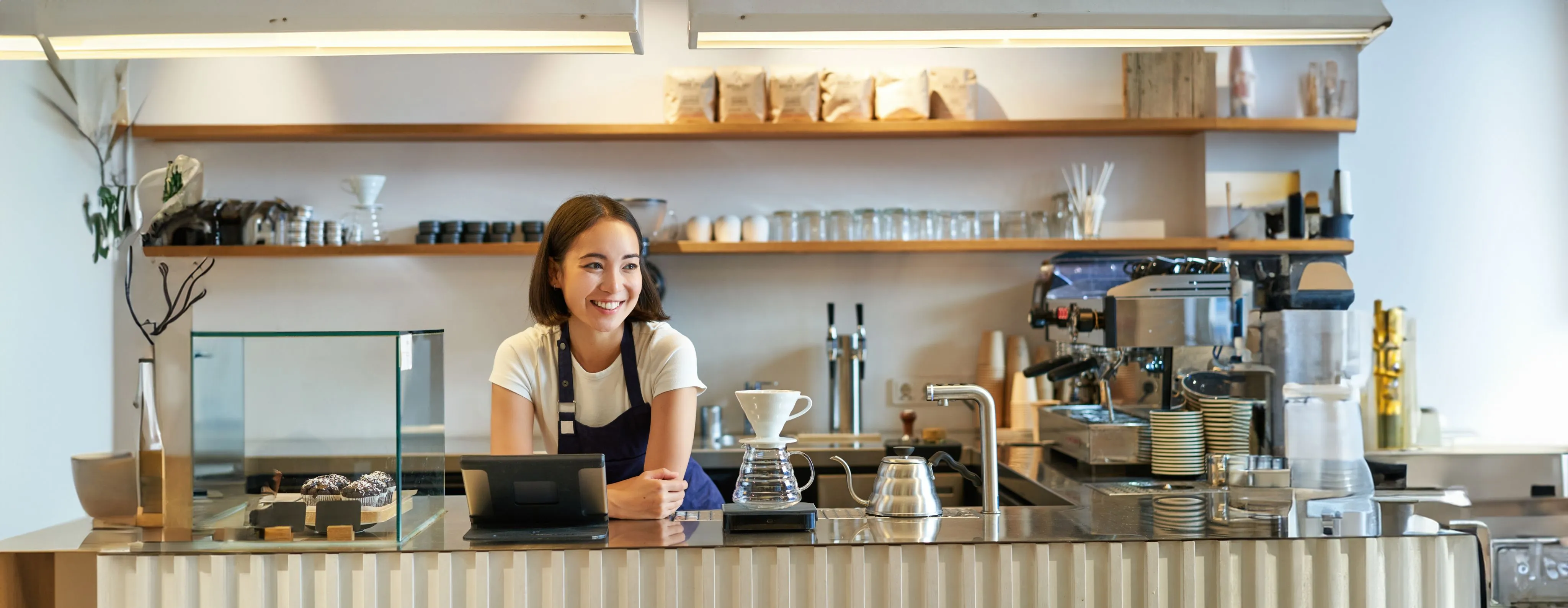 A barista behind the counter of a coffee shop