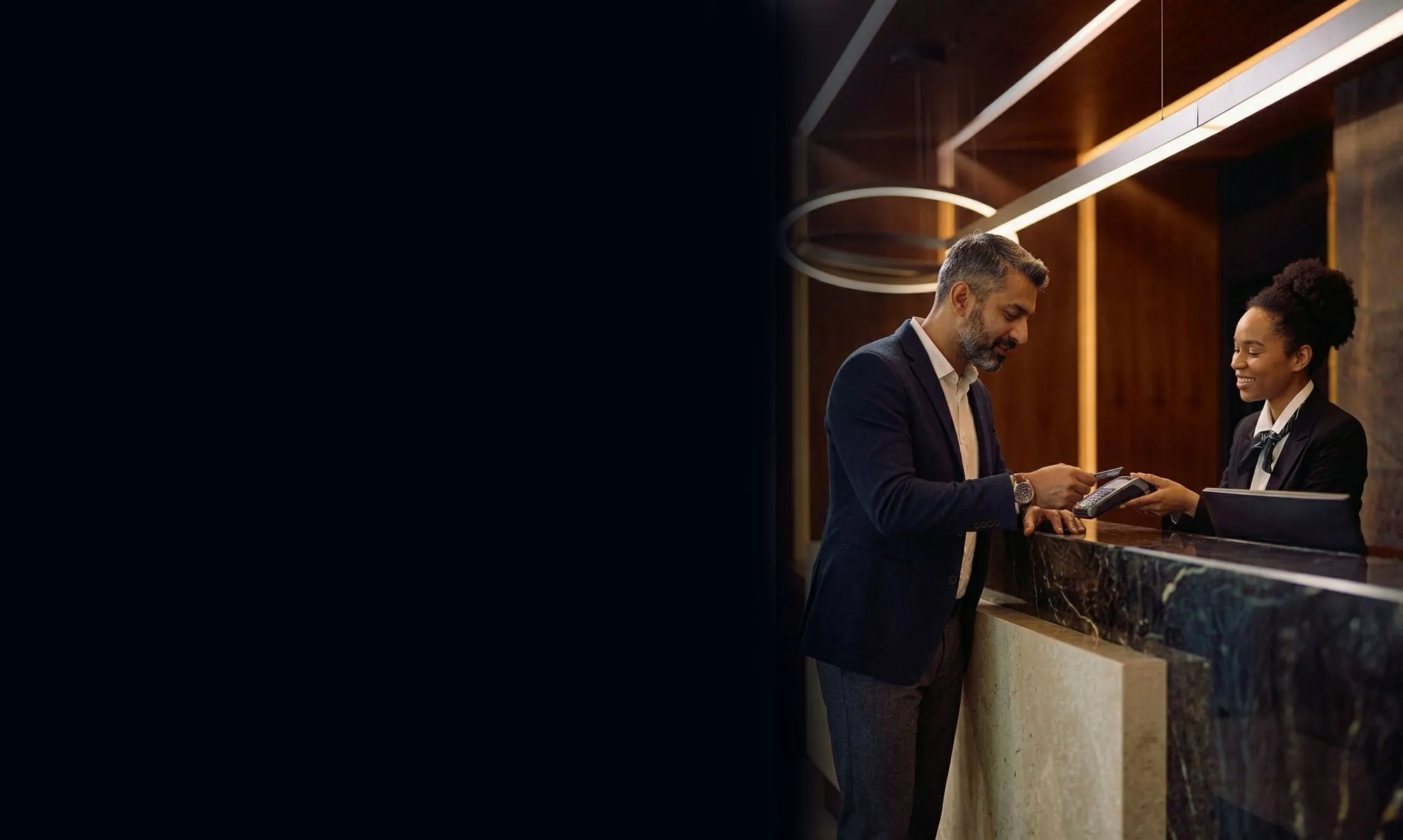 A guest paying at a hotel reception desk